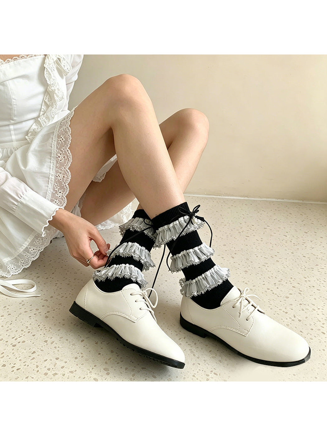 Black ruffle socks styled with white lace-up shoes