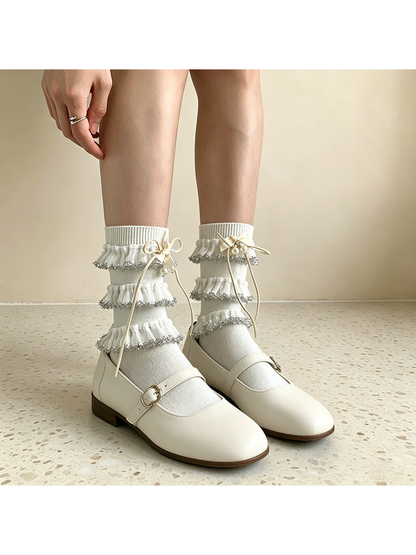 White ruffle socks styled with buckle-strap shoes, front view