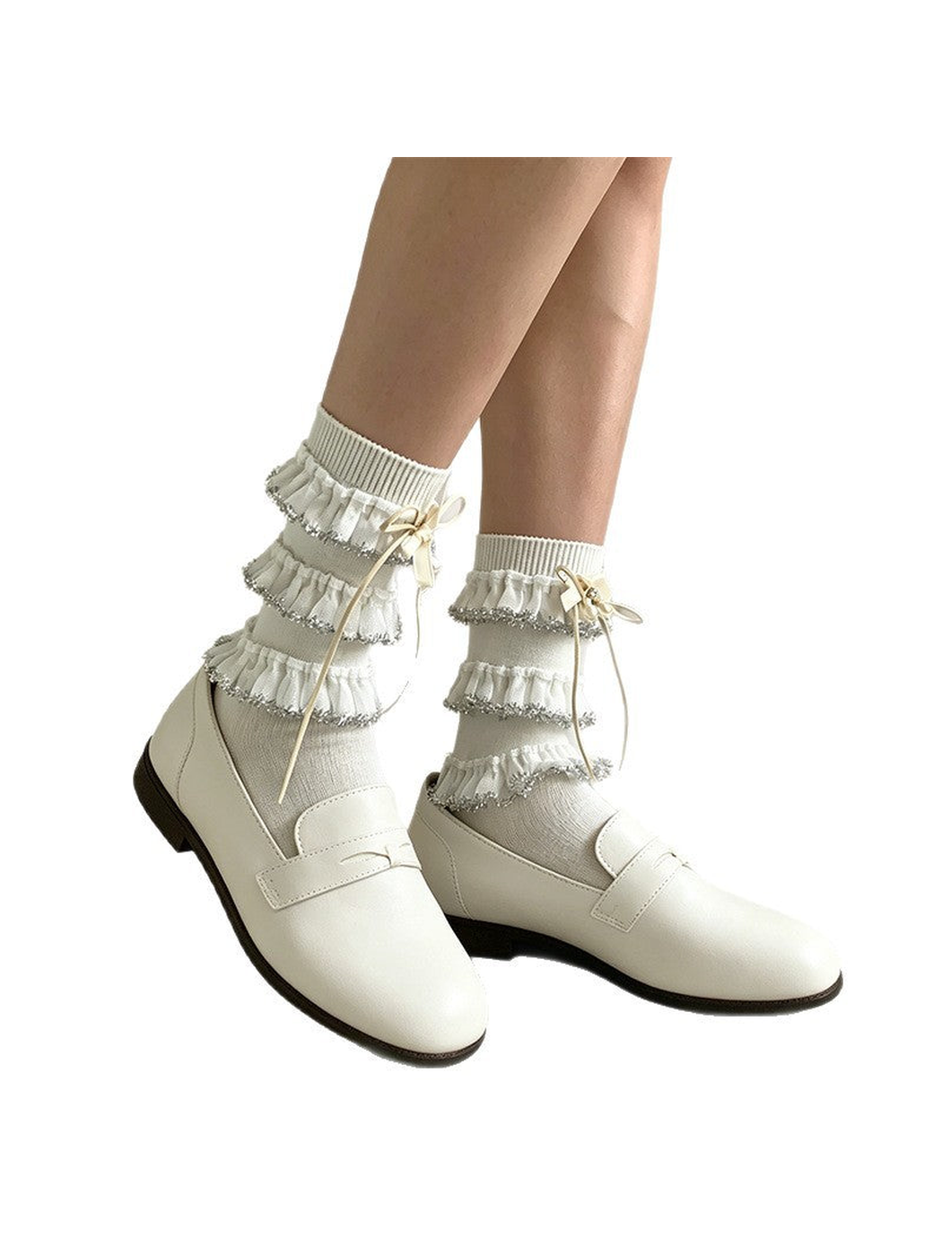 White tiered-ruffle socks styled with loafers against a white background