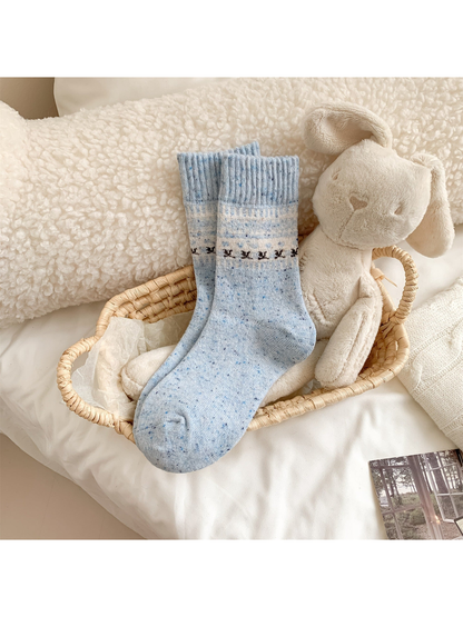 Light blue crew socks with a small animal motif band