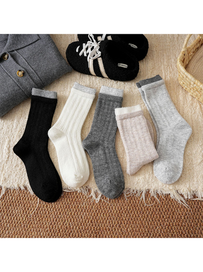 Five ribbed crew sock colors arranged with winter accessories