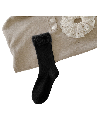 Black ribbed crew sock with a wide fuzzy cuff laid flat
