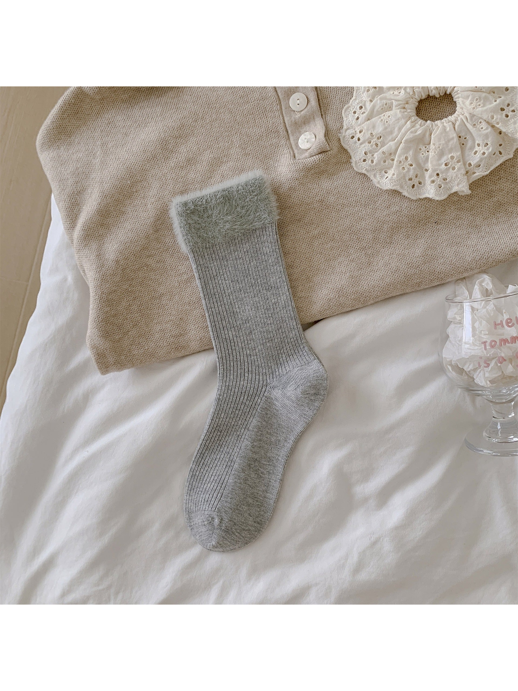 Light gray ribbed crew sock with a wide fuzzy cuff laid flat