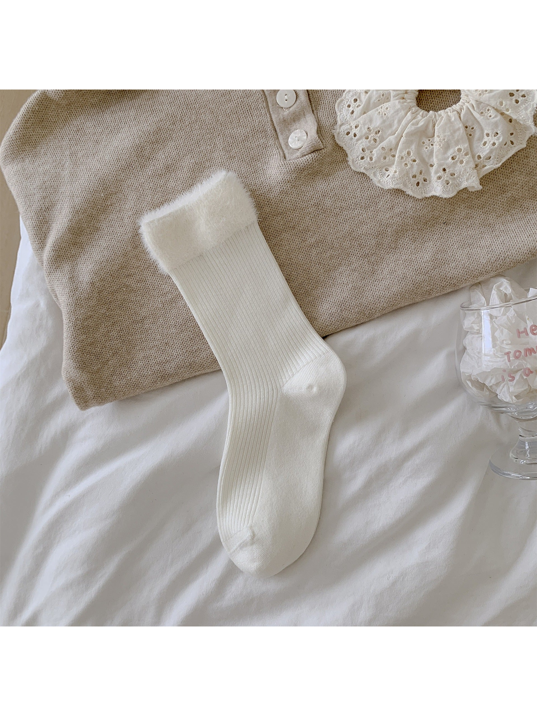 White ribbed crew sock with a wide fuzzy cuff laid flat