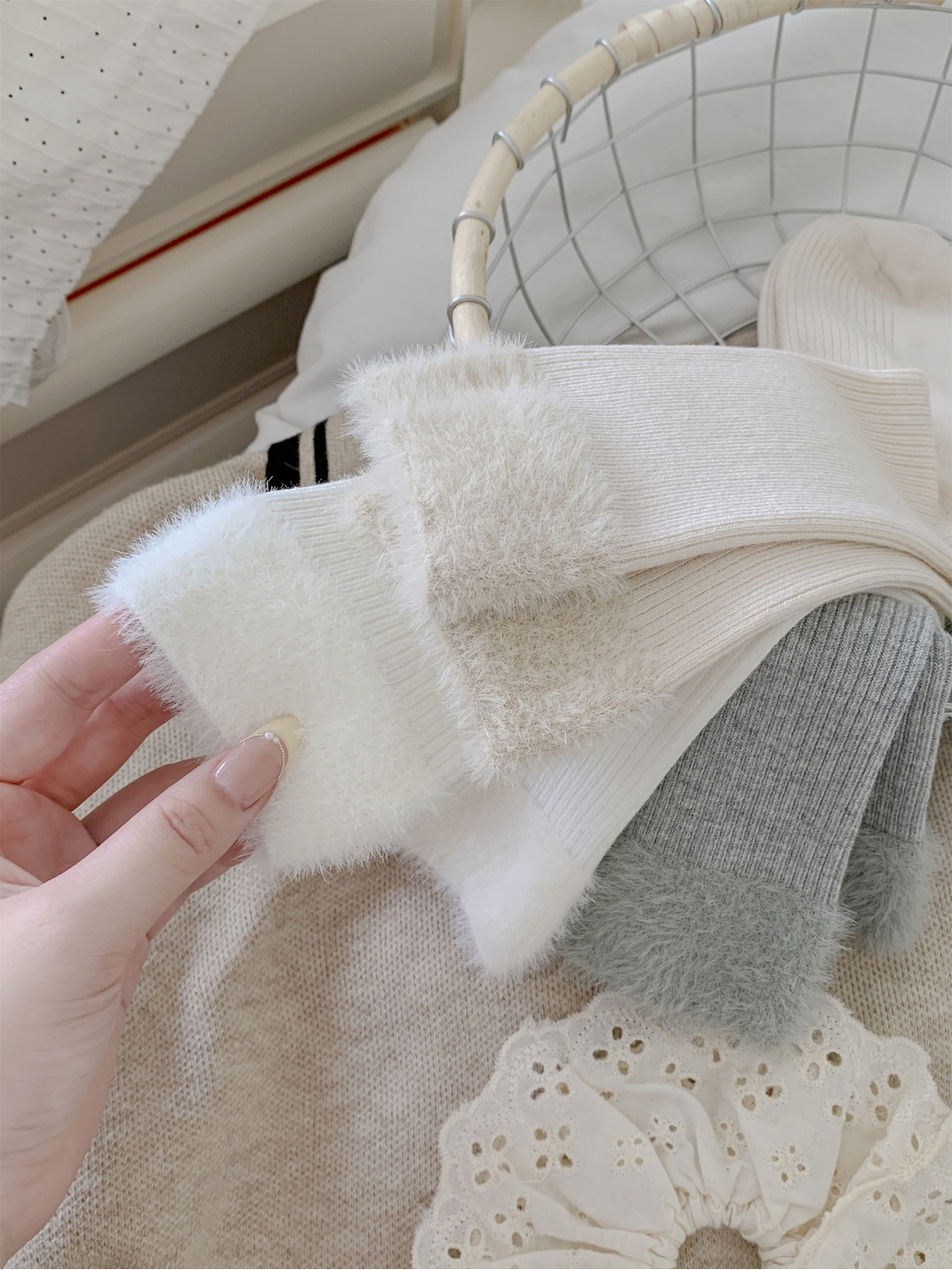 Close-up of white and cream fuzzy sock cuffs and ribbed knit