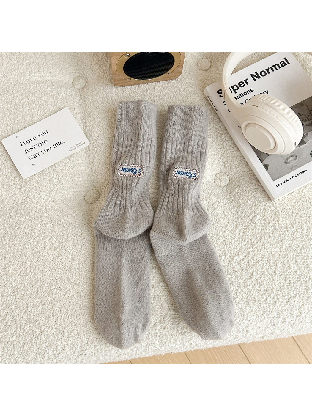 Light gray ribbed crew socks with distressed openings and sewn label patches