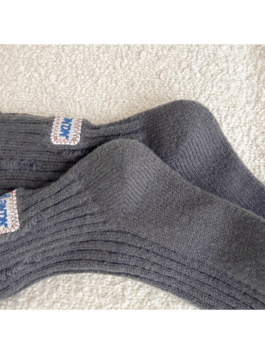 Close-up of the shaped heel and ribbed leg on dark gray crew socks