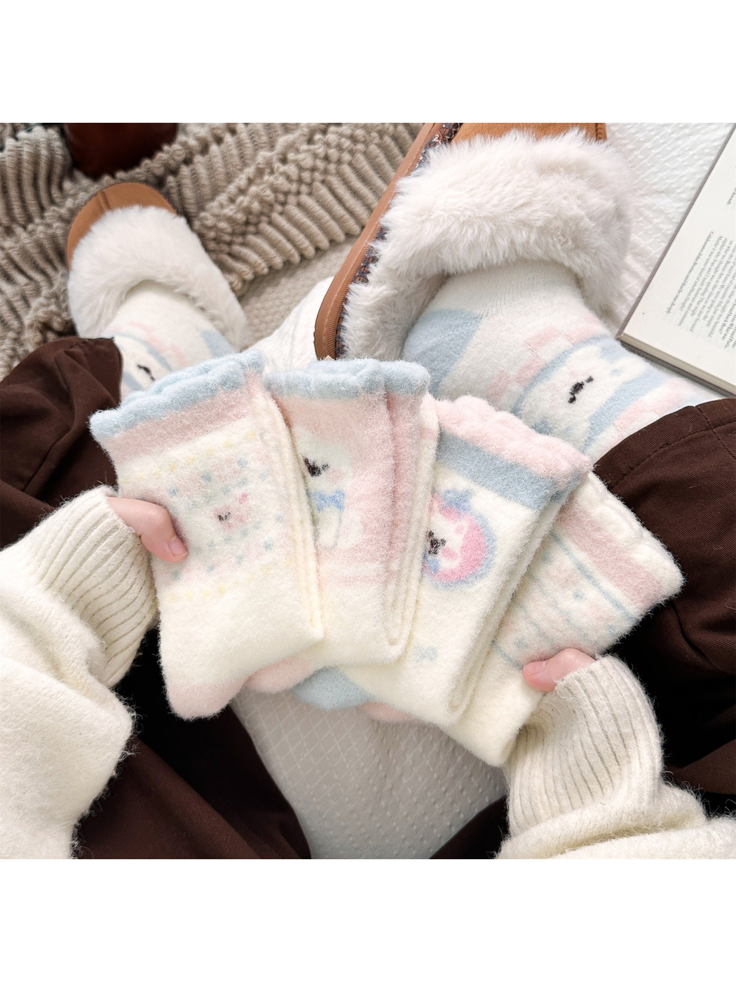 Pastel fuzzy crew socks displayed by hand beside matching slipper styling