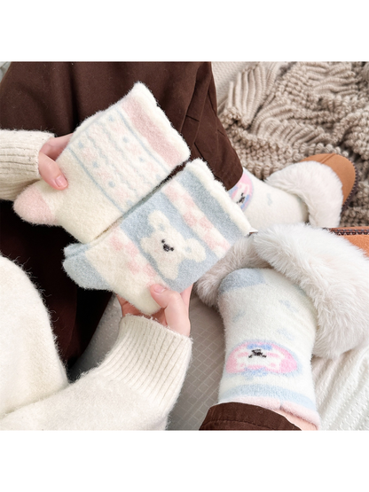 Pastel striped and blue dog motif fuzzy socks held beside a worn round dog pair