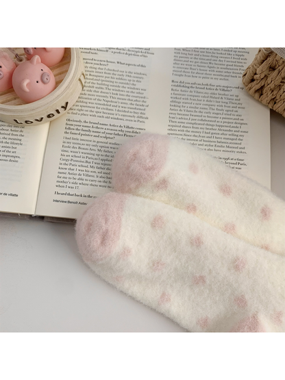 Close-up of the cream fuzzy sock surface with pink dot pattern and contrasting heel