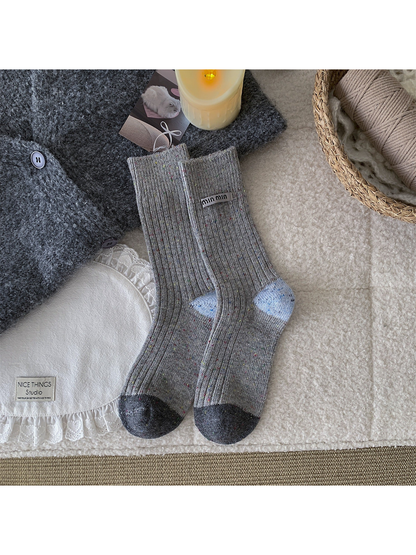 Gray speckled crew socks with light blue heels and dark gray toes