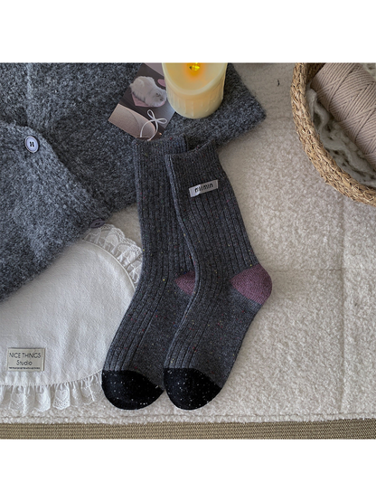 Dark gray speckled crew socks with purple heels and black toes