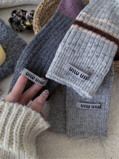 Close-up of ribbed gray socks with multicolored flecks and fuzzy stripe trim