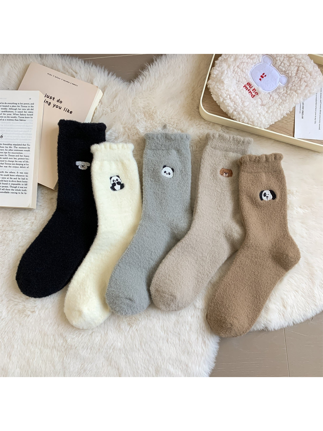 Five fuzzy crew sock colors with embroidered animal motifs displayed together