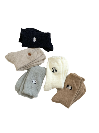 Five folded fuzzy crew sock colors with embroidered animal motifs on a white background