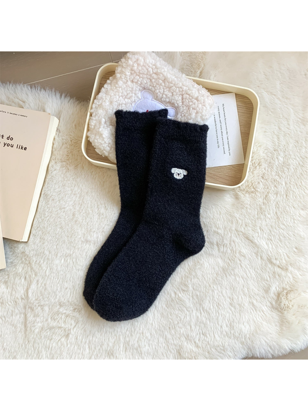 Black fuzzy crew socks with a small embroidered dog face motif