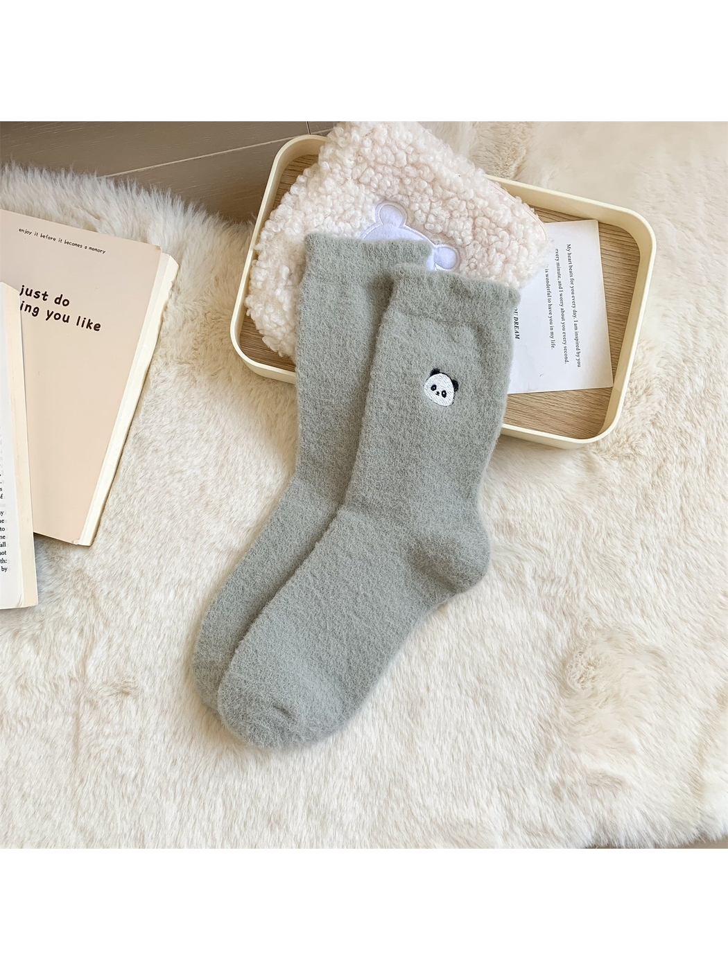 Gray-blue fuzzy crew socks with a small embroidered panda face motif