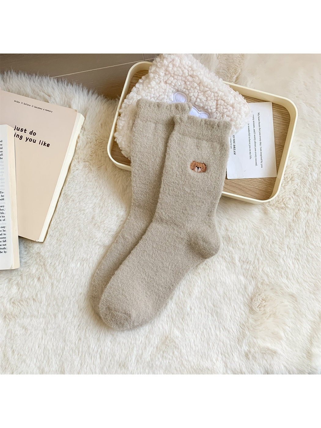 Greige fuzzy crew socks with a small embroidered bear face motif