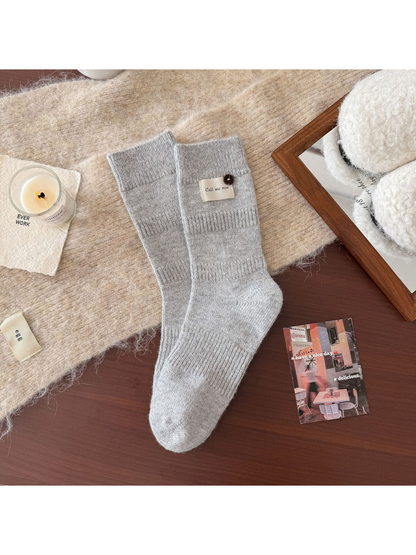 Light gray ribbed crew socks with fabric label and button detail