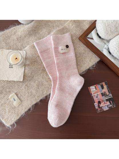 Light pink ribbed crew socks with fabric label and button detail