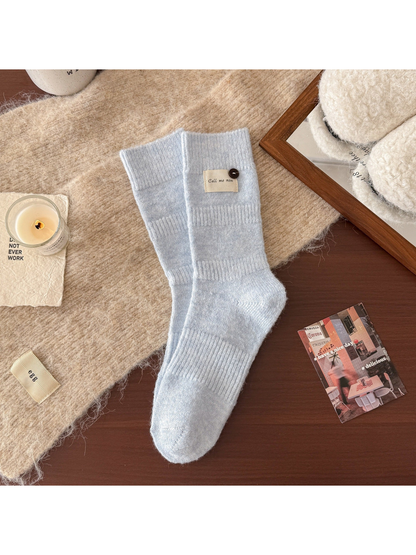 Light blue ribbed crew socks with fabric label and button detail