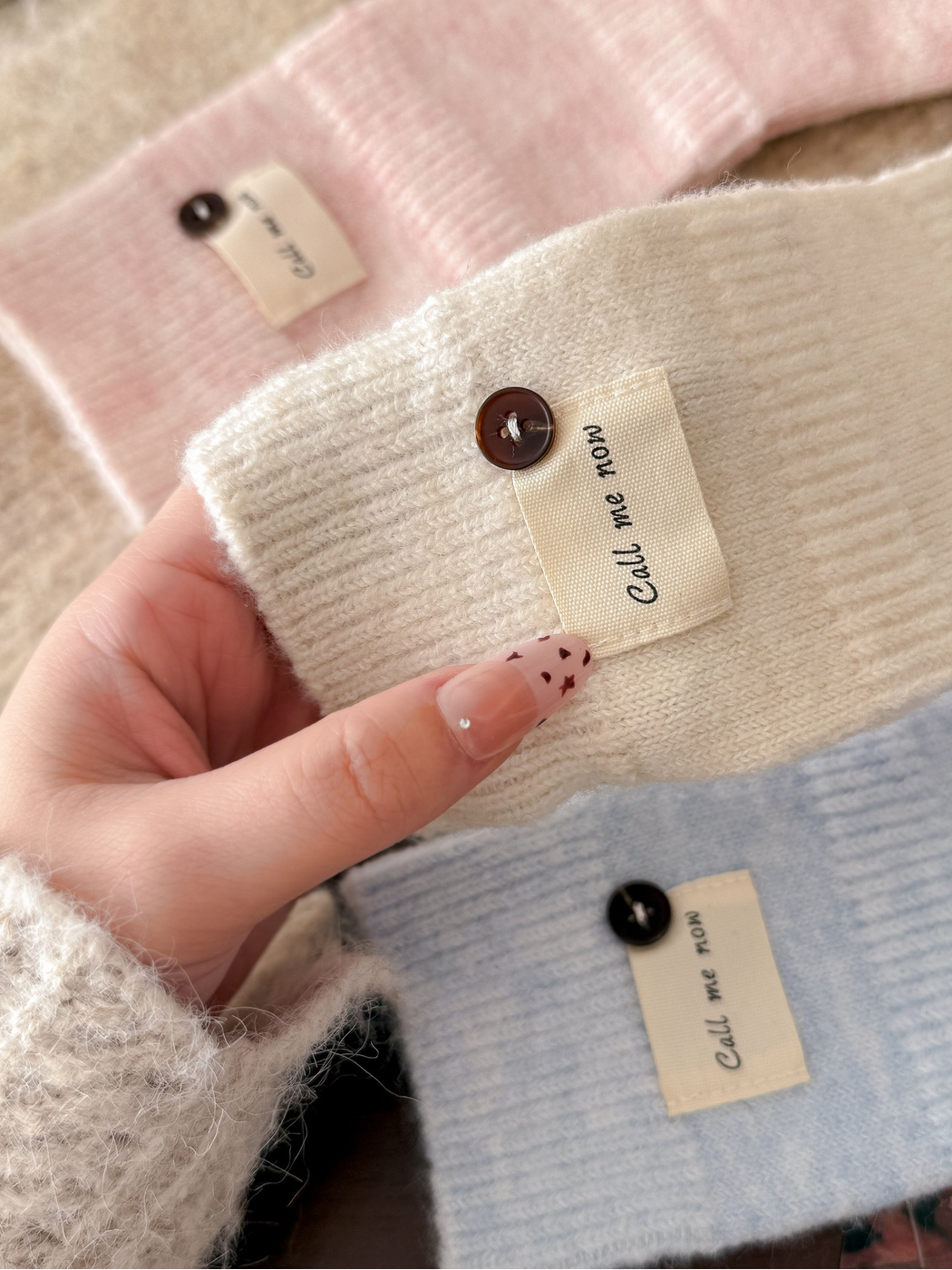 Close-up of the knit texture, fabric label and button detail