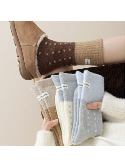 Fuzzy polka-dot crew socks displayed in several colors with one brown pair worn with a shoe