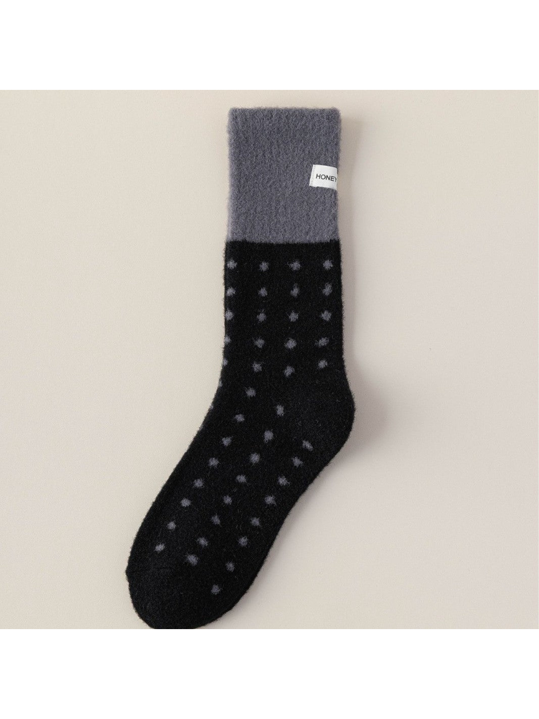 Black fuzzy crew sock with dark gray cuff and polka dots