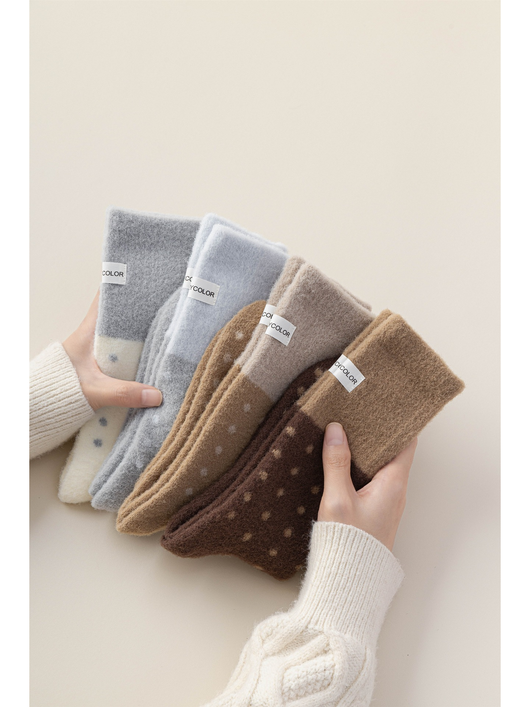Five fuzzy polka-dot crew sock colors fanned between two hands