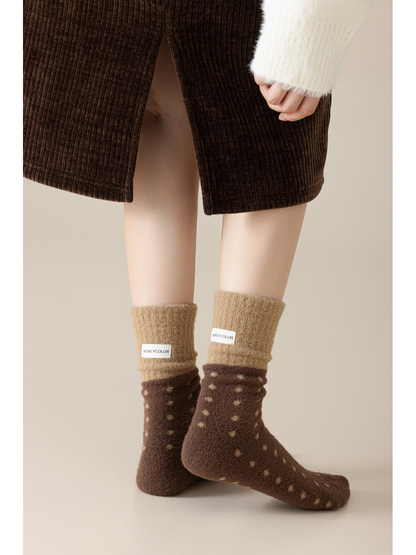 Dark brown fuzzy polka-dot crew socks worn in a crossed-leg pose