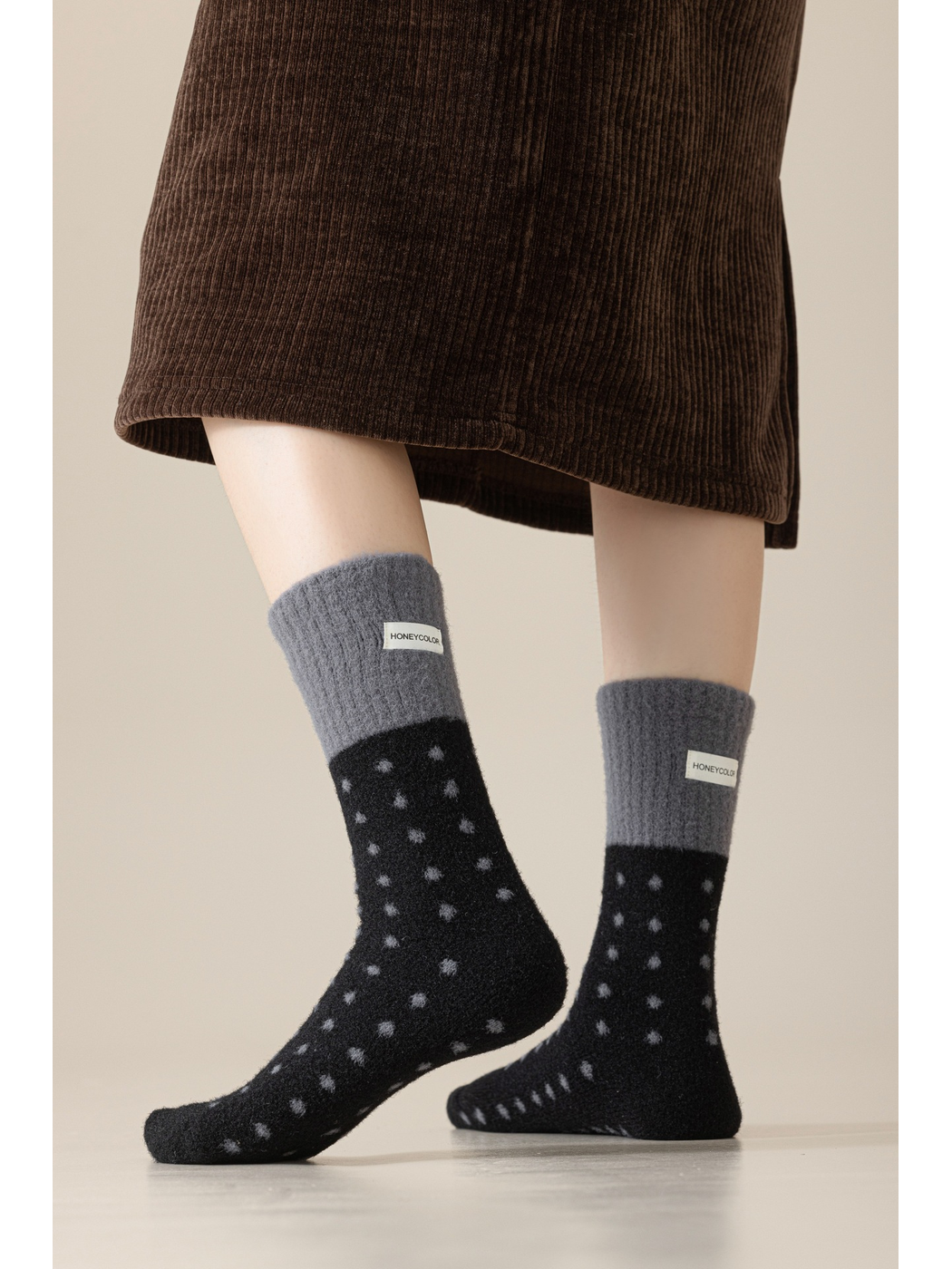Black fuzzy polka-dot crew socks worn with contrasting dark gray cuffs