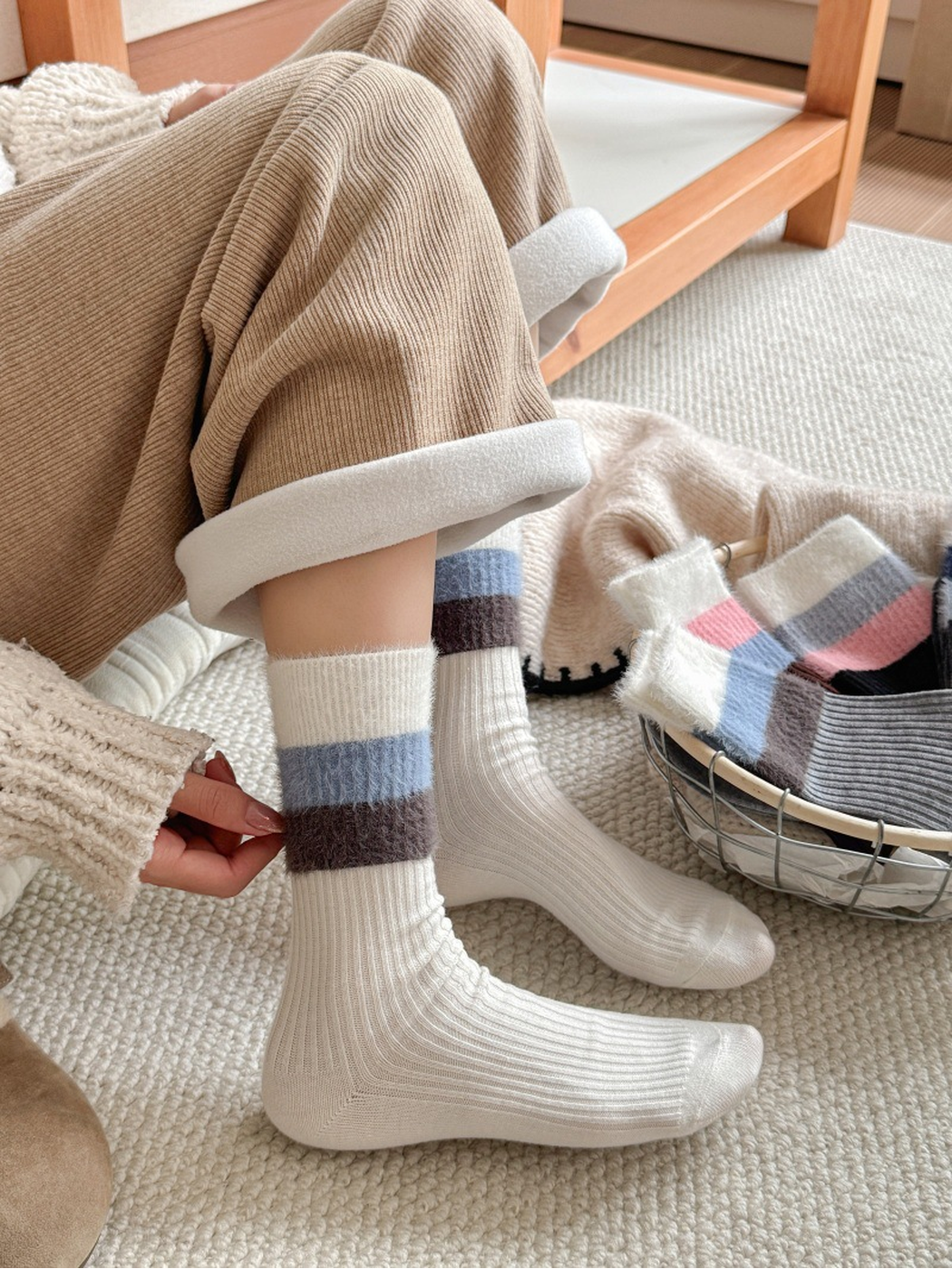 Cream striped-cuff crew socks worn with lined clogs beside a basket of color variants