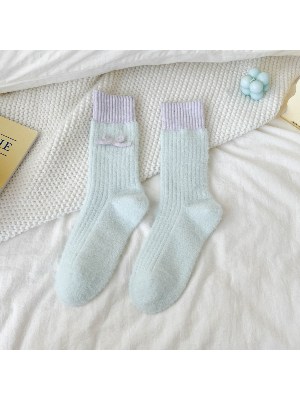 Light blue fuzzy ribbed crew socks with lavender cuffs and bow