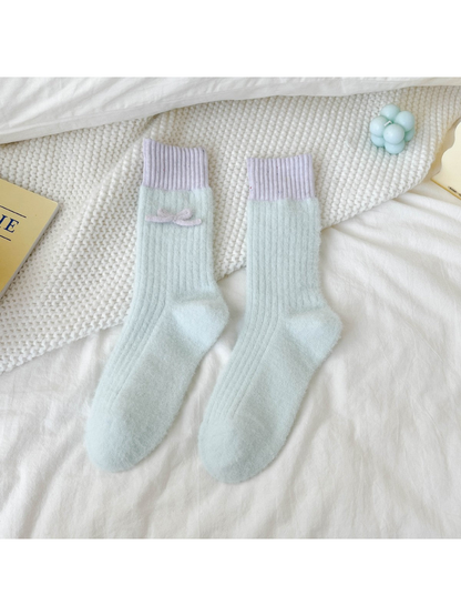 Light blue fuzzy ribbed crew socks with lavender cuffs and bow