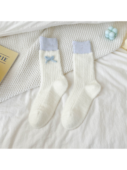 Ivory fuzzy ribbed crew socks with lavender cuffs and blue bow