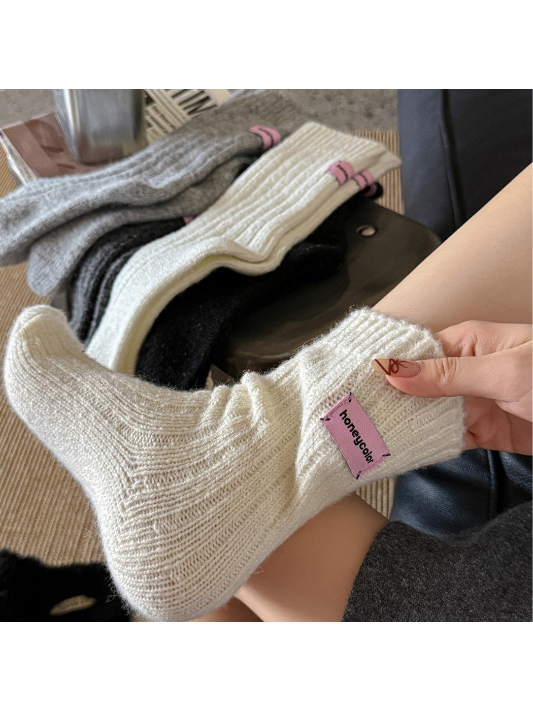 Cream ribbed crew sock worn in a close-up view with other colors displayed behind