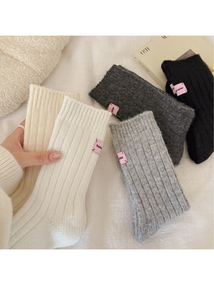 Cream, white, light gray, dark gray and black ribbed crew socks displayed together