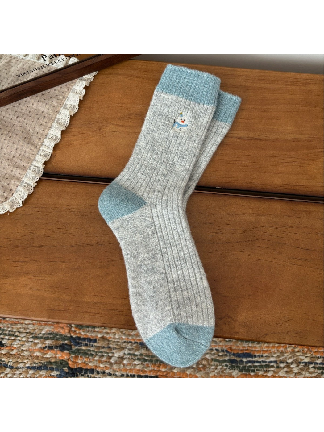 Light gray ribbed crew socks with blue trim and snowman embroidery