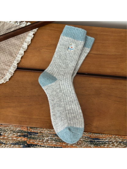 Light gray ribbed crew socks with blue trim and snowman embroidery
