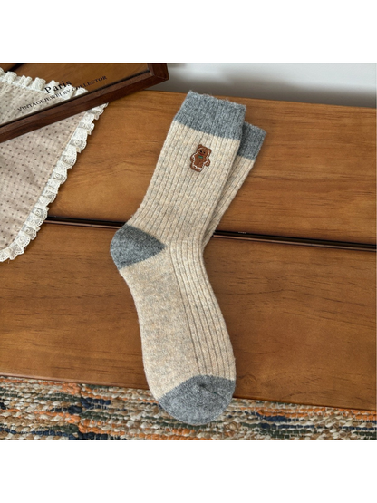Beige ribbed crew socks with gray trim and gingerbread figure embroidery