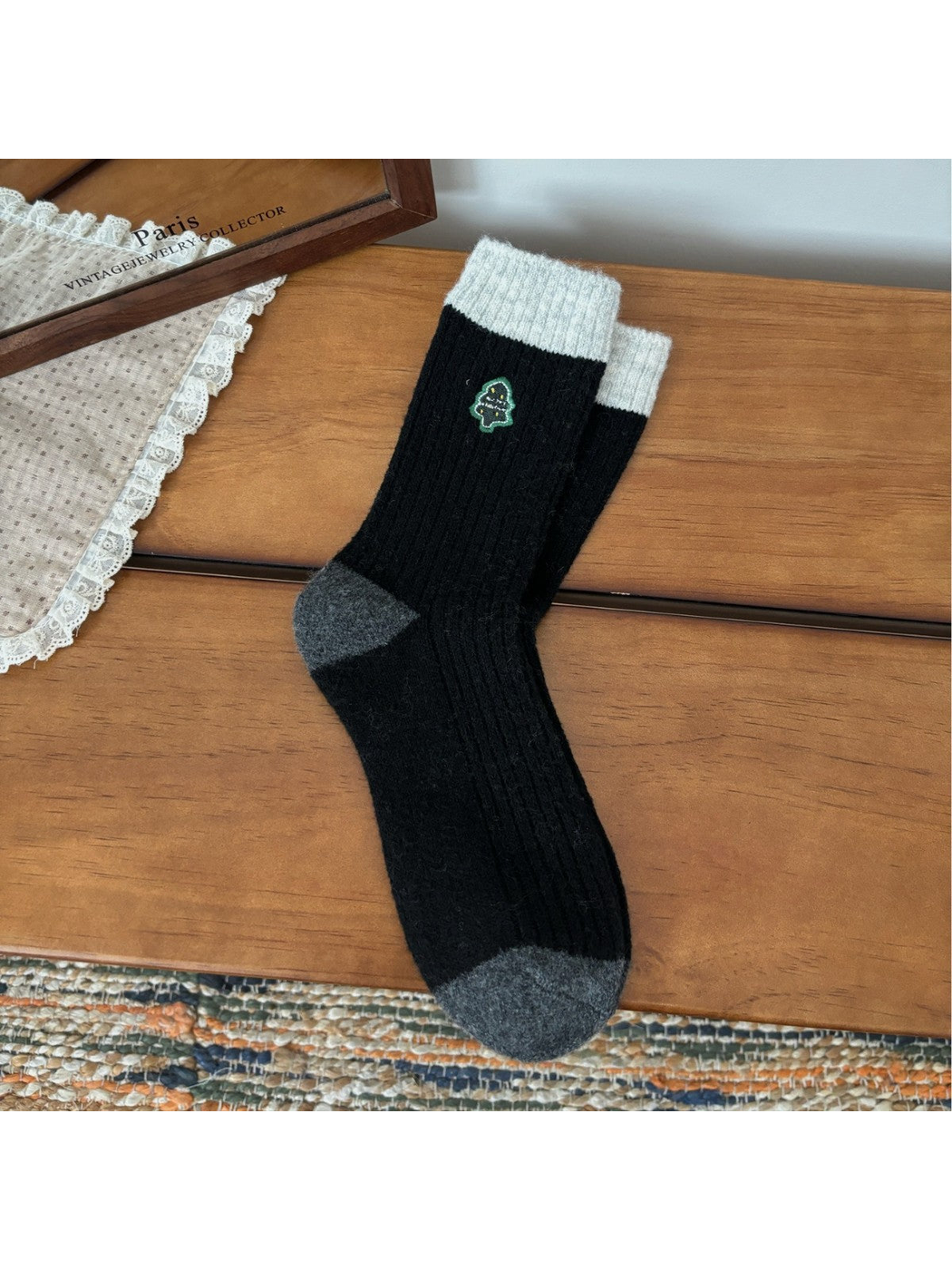 Black ribbed crew socks with light cuffs, gray trim and Christmas tree embroidery