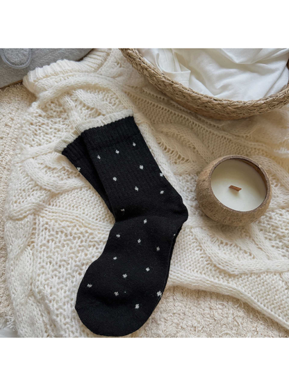 Black polka-dot crew socks with a contrasting ruffled cuff