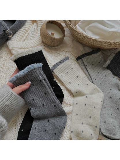 Black, ivory and gray polka-dot crew socks arranged together