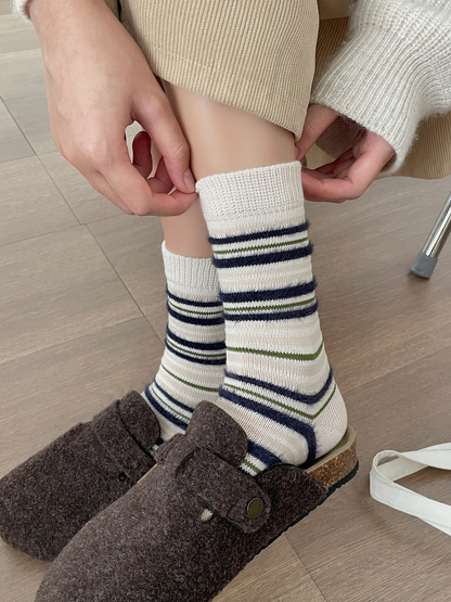 Close-up of the ivory ribbed cuffs and striped knit texture
