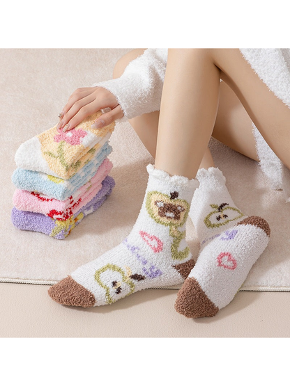 White character-motif fuzzy crew socks worn beside a stack of colorful styles