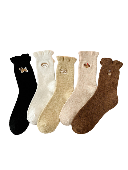 Five fuzzy crew sock styles with embroidered motifs displayed together