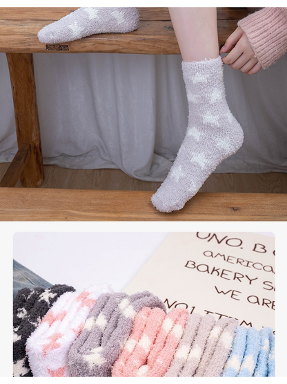 Pale purple star socks worn on a bench with folded colors below