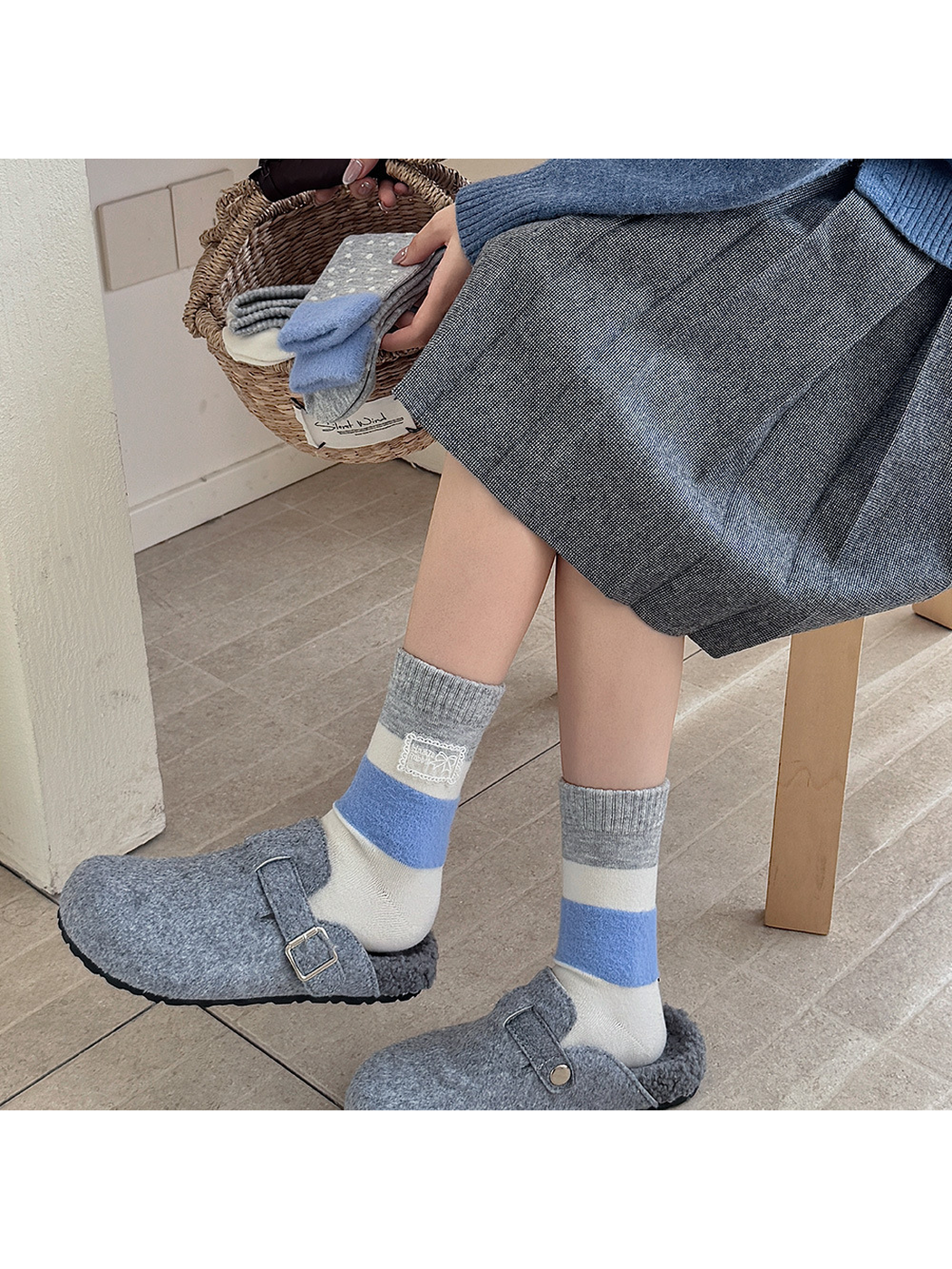 Gray, cream and blue color-block crew socks worn with gray clogs