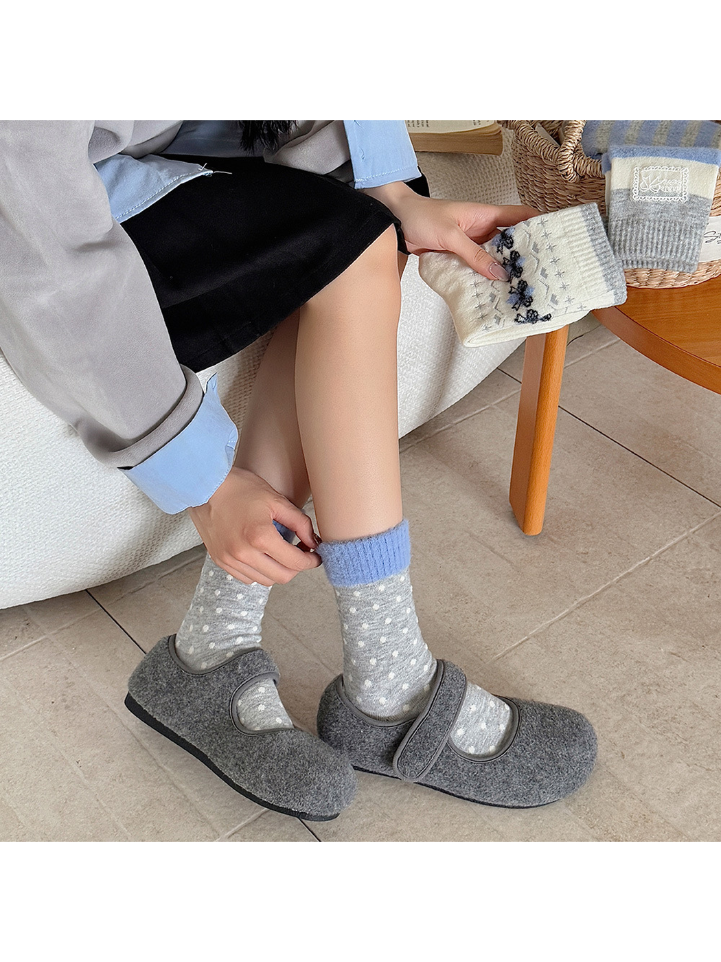Gray polka-dot crew socks with blue fuzzy cuffs worn with gray clogs