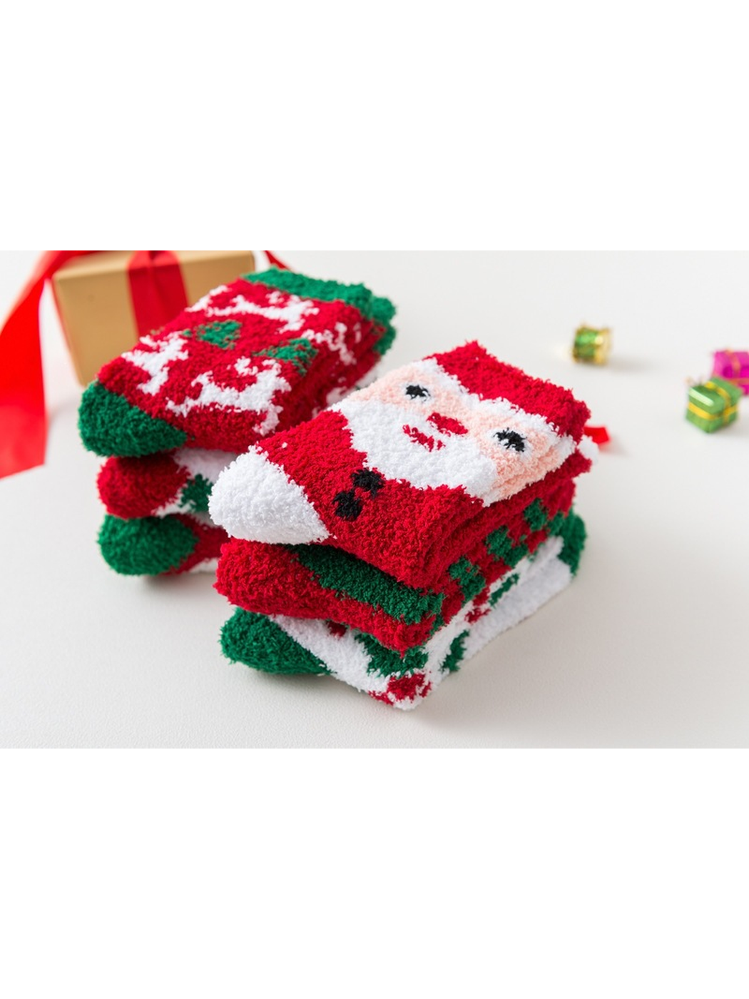 Stacks of folded fuzzy holiday socks with Santa and reindeer designs